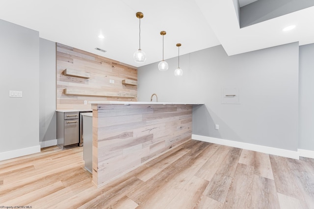 bar with pendant lighting, light wood-type flooring, and wood walls