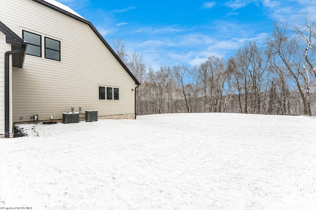 snowy yard featuring cooling unit