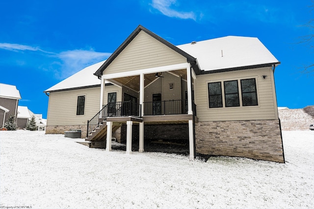 snow covered house featuring ceiling fan