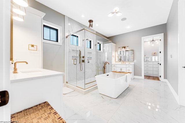 bathroom featuring ceiling fan, plus walk in shower, and vanity