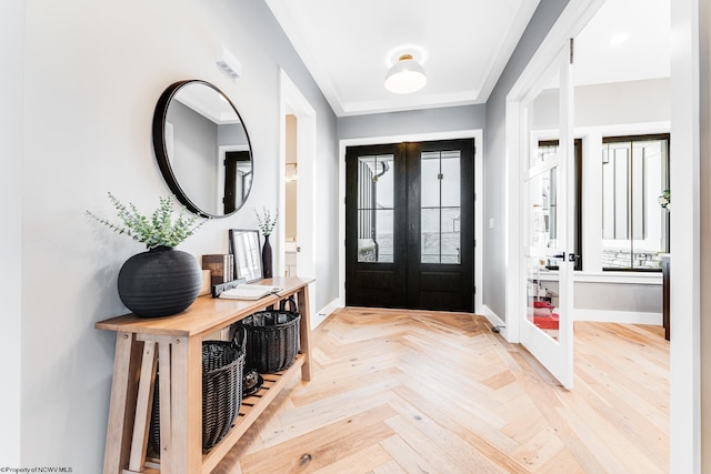 entrance foyer with ornamental molding, light parquet floors, and french doors