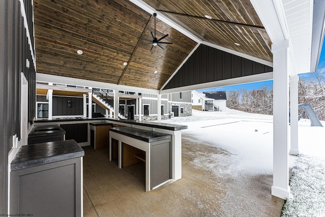 snow covered patio with ceiling fan and a bar