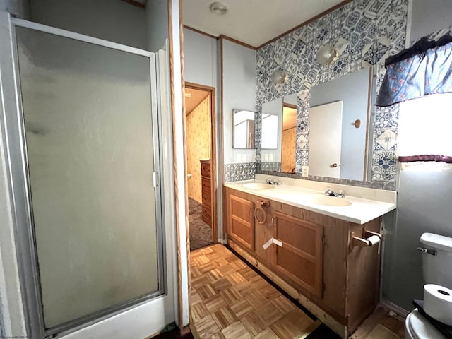 bathroom with parquet flooring, an enclosed shower, and vanity