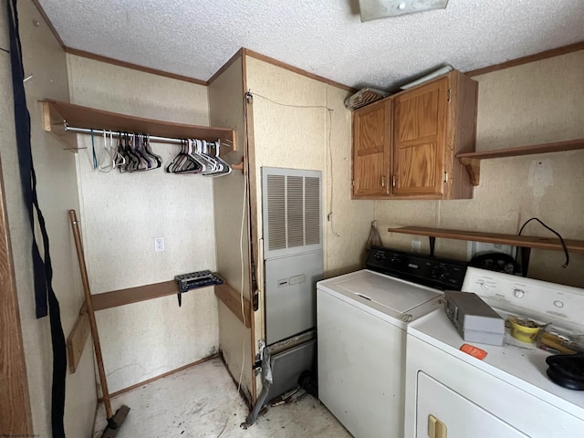 washroom featuring a textured ceiling, crown molding, cabinets, and independent washer and dryer