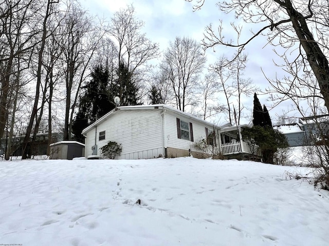 snow covered property featuring covered porch