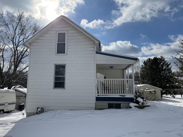 view of snow covered exterior featuring covered porch