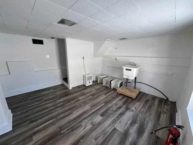 clothes washing area with sink and dark hardwood / wood-style flooring