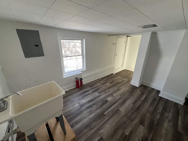 unfurnished room featuring electric panel, dark hardwood / wood-style flooring, a paneled ceiling, and sink