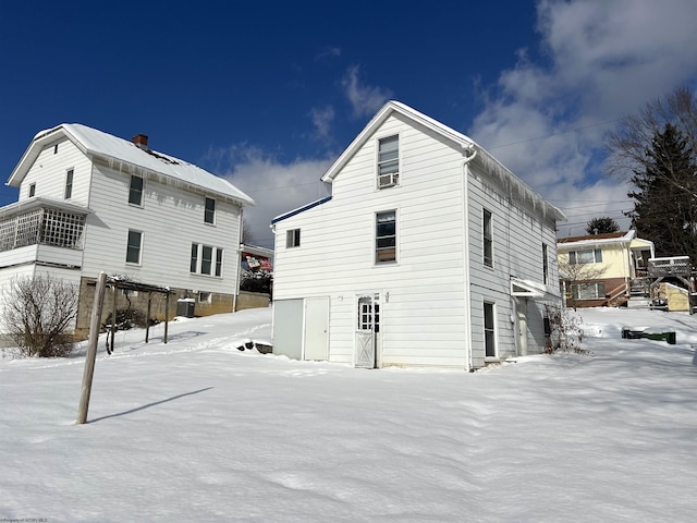 snow covered rear of property with central AC unit