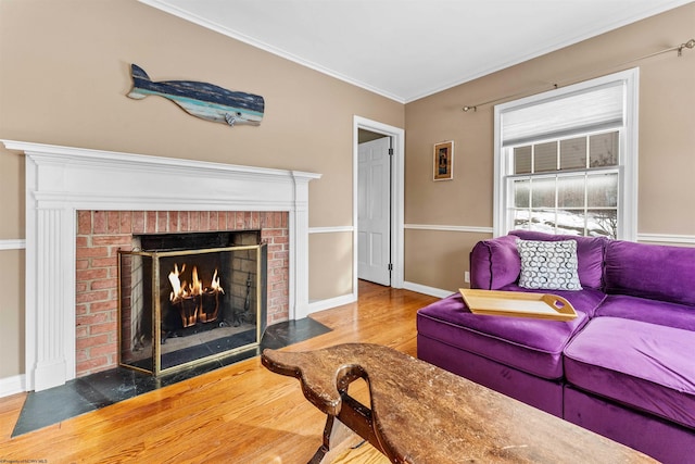 living room featuring wood-type flooring, a brick fireplace, and crown molding