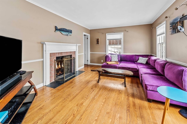 living room with ornamental molding, a fireplace, and hardwood / wood-style flooring