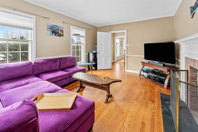 living room with hardwood / wood-style floors, a brick fireplace, and crown molding