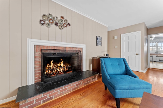 sitting room with a fireplace, hardwood / wood-style flooring, and crown molding