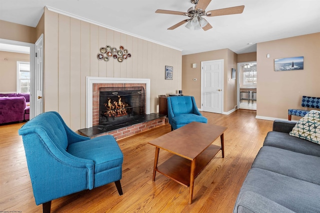 living room featuring a brick fireplace, ceiling fan, and light hardwood / wood-style flooring