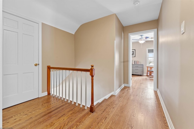 corridor with vaulted ceiling and light hardwood / wood-style floors