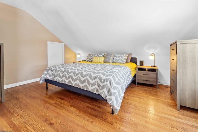 bedroom featuring light hardwood / wood-style floors and vaulted ceiling