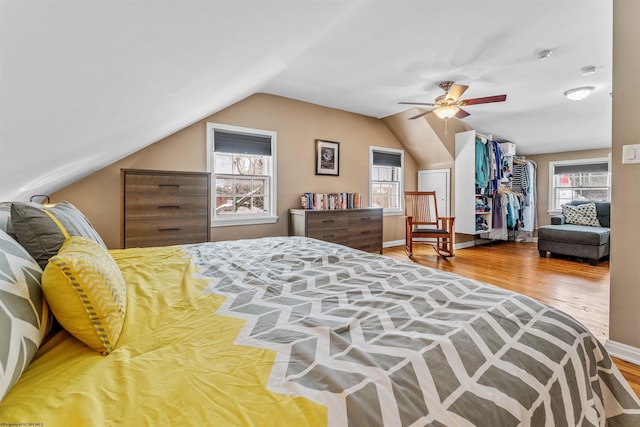 bedroom with lofted ceiling, wood-type flooring, multiple windows, and ceiling fan