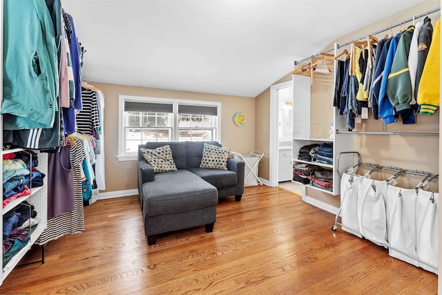 walk in closet with lofted ceiling and hardwood / wood-style floors