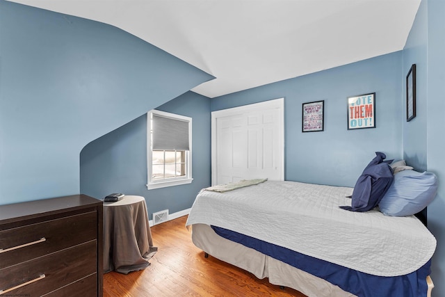 bedroom featuring a closet, lofted ceiling, and hardwood / wood-style flooring