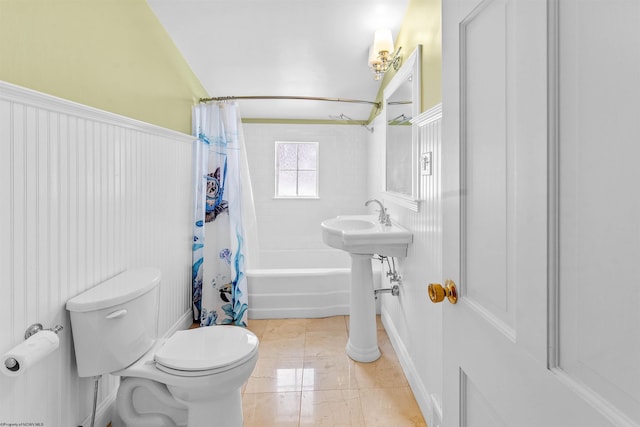 bathroom with toilet, tile patterned flooring, and shower / bath combo with shower curtain