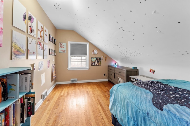 bedroom with lofted ceiling and light hardwood / wood-style floors