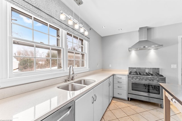 kitchen featuring appliances with stainless steel finishes, exhaust hood, pendant lighting, sink, and light tile patterned flooring