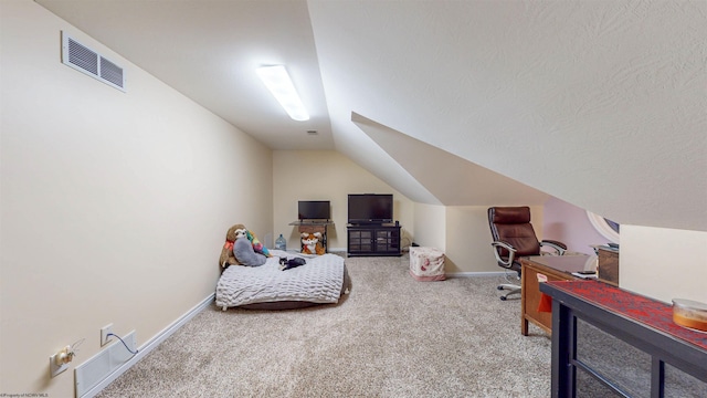 carpeted bedroom featuring a textured ceiling and lofted ceiling