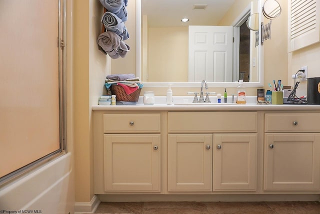 bathroom featuring vanity and shower / bath combination with glass door