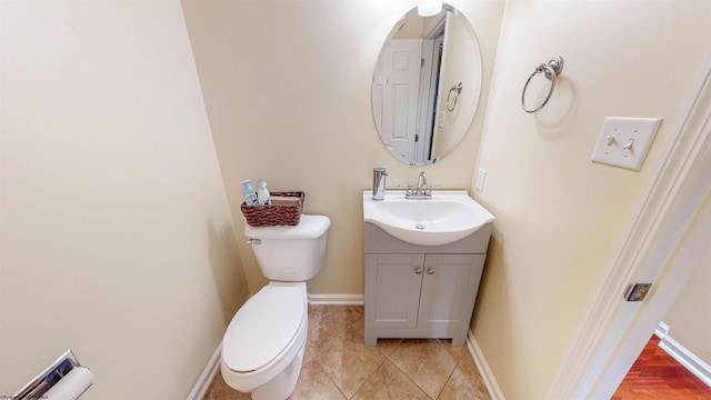 bathroom with toilet, tile patterned floors, and vanity