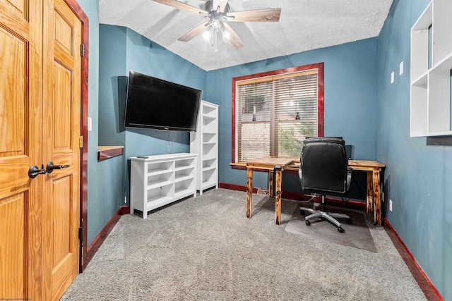 carpeted home office with ceiling fan and a textured ceiling