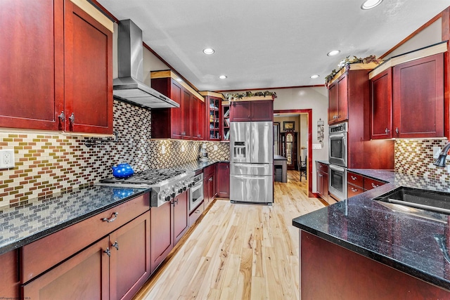 kitchen with decorative backsplash, sink, appliances with stainless steel finishes, and wall chimney exhaust hood