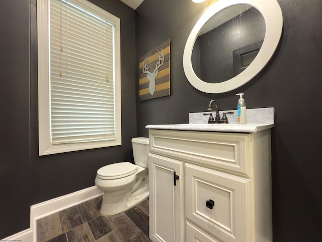 bathroom with toilet, wood-type flooring, and vanity