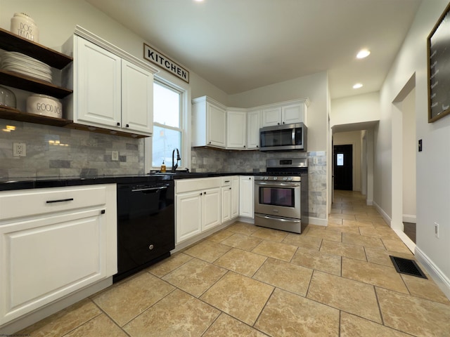 kitchen featuring appliances with stainless steel finishes, decorative backsplash, white cabinets, and sink