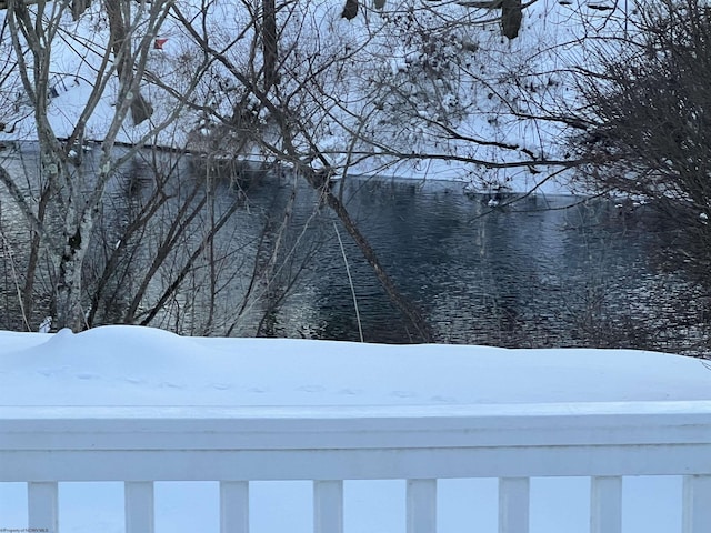 yard covered in snow featuring a water view