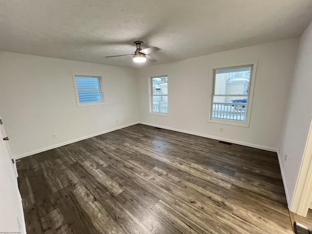 spare room with ceiling fan, a textured ceiling, and dark hardwood / wood-style floors