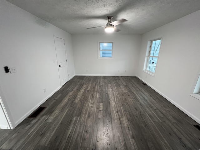 spare room featuring ceiling fan, dark wood-type flooring, and a textured ceiling