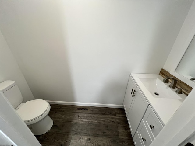 bathroom featuring toilet, hardwood / wood-style flooring, and vanity