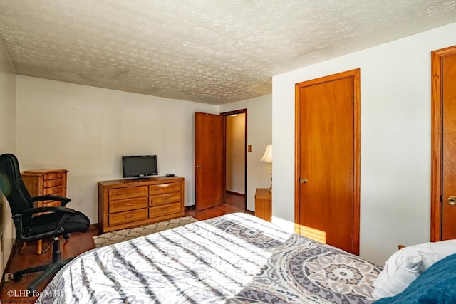 bedroom with a textured ceiling and wood finished floors