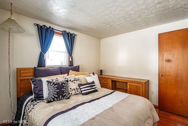 bedroom featuring a textured ceiling and wood finished floors