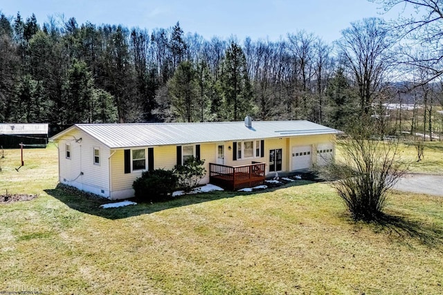 ranch-style home with a garage, metal roof, a front lawn, and a porch