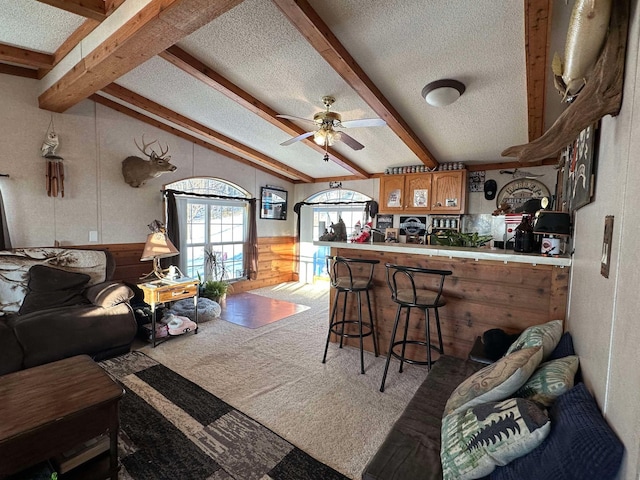 kitchen featuring light carpet, ceiling fan, a textured ceiling, and beamed ceiling