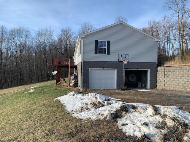 view of side of home featuring a lawn, a deck, and a garage