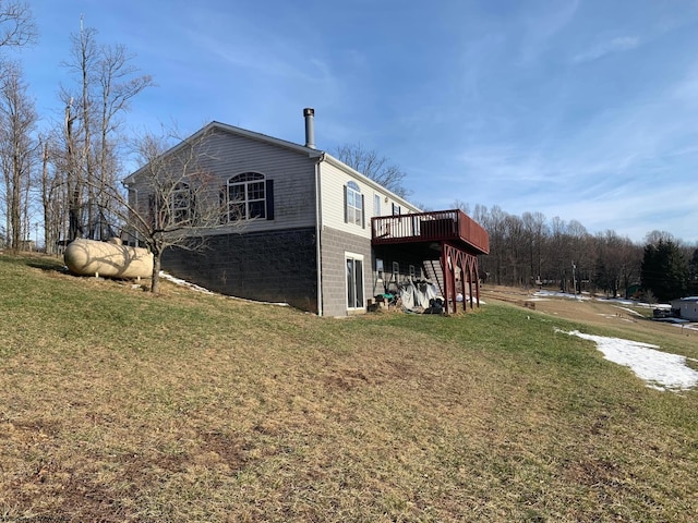 view of side of property featuring a deck and a yard