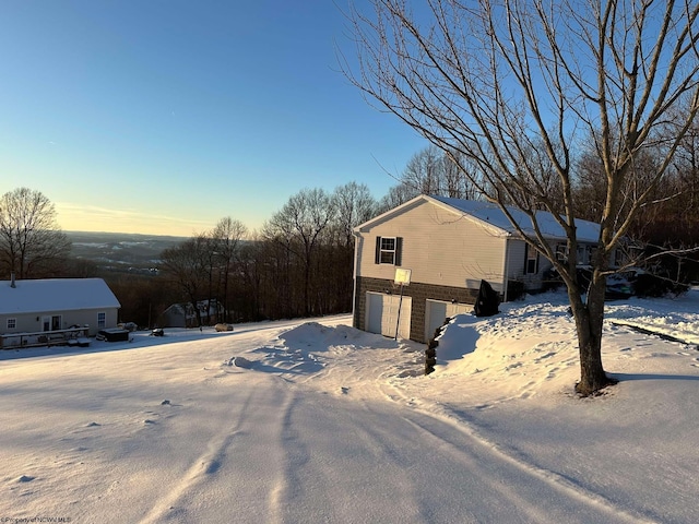 view of snowy exterior featuring a garage