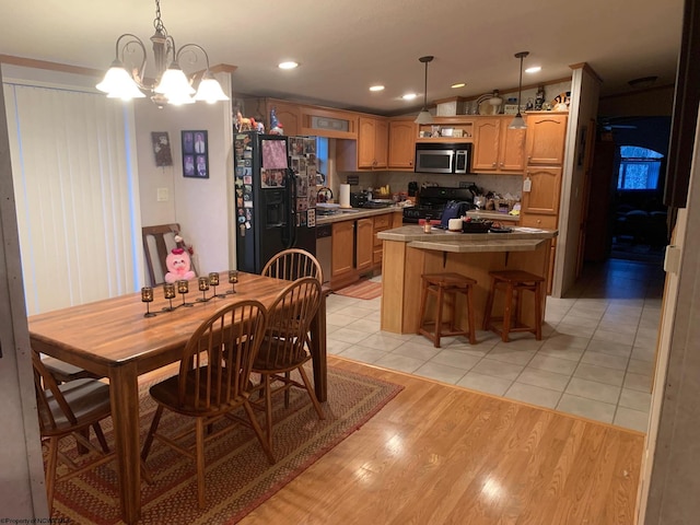 dining space featuring light tile patterned floors, a notable chandelier, and sink