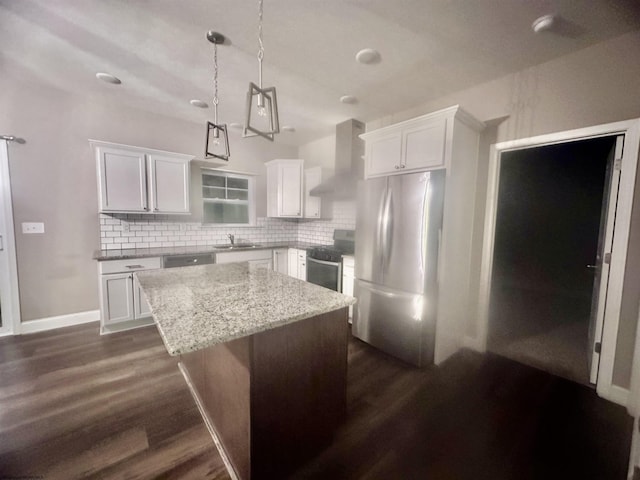 kitchen with stainless steel appliances, white cabinetry, a center island, and wall chimney exhaust hood