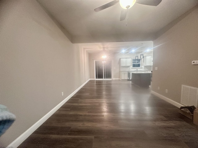 interior space featuring dark hardwood / wood-style flooring, vaulted ceiling, and ceiling fan