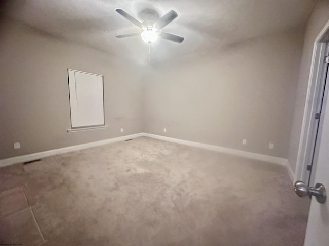 carpeted spare room featuring ceiling fan