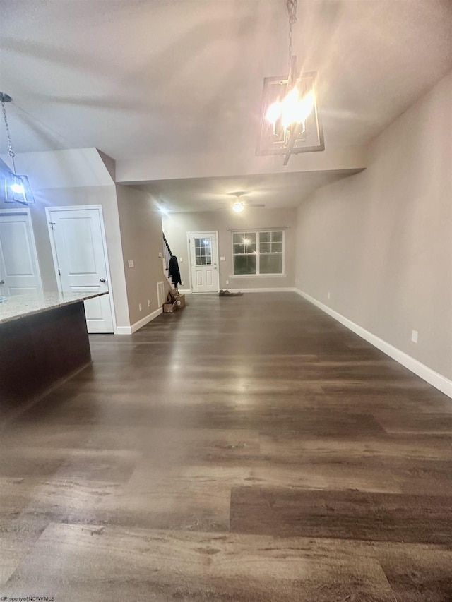 unfurnished living room with dark hardwood / wood-style floors and a notable chandelier