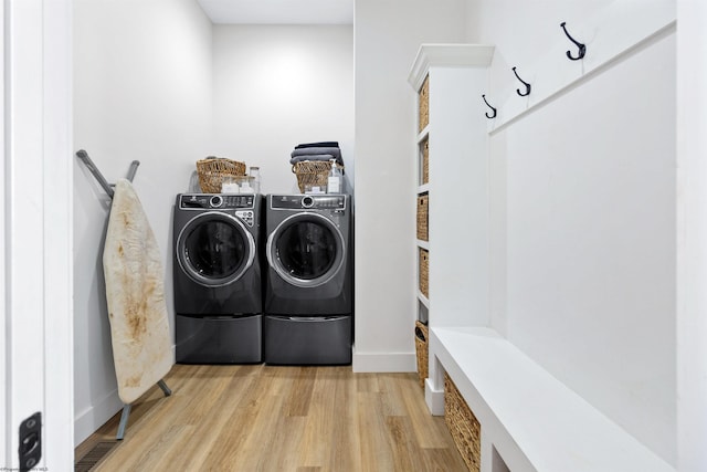 clothes washing area with light wood-type flooring and washer and clothes dryer